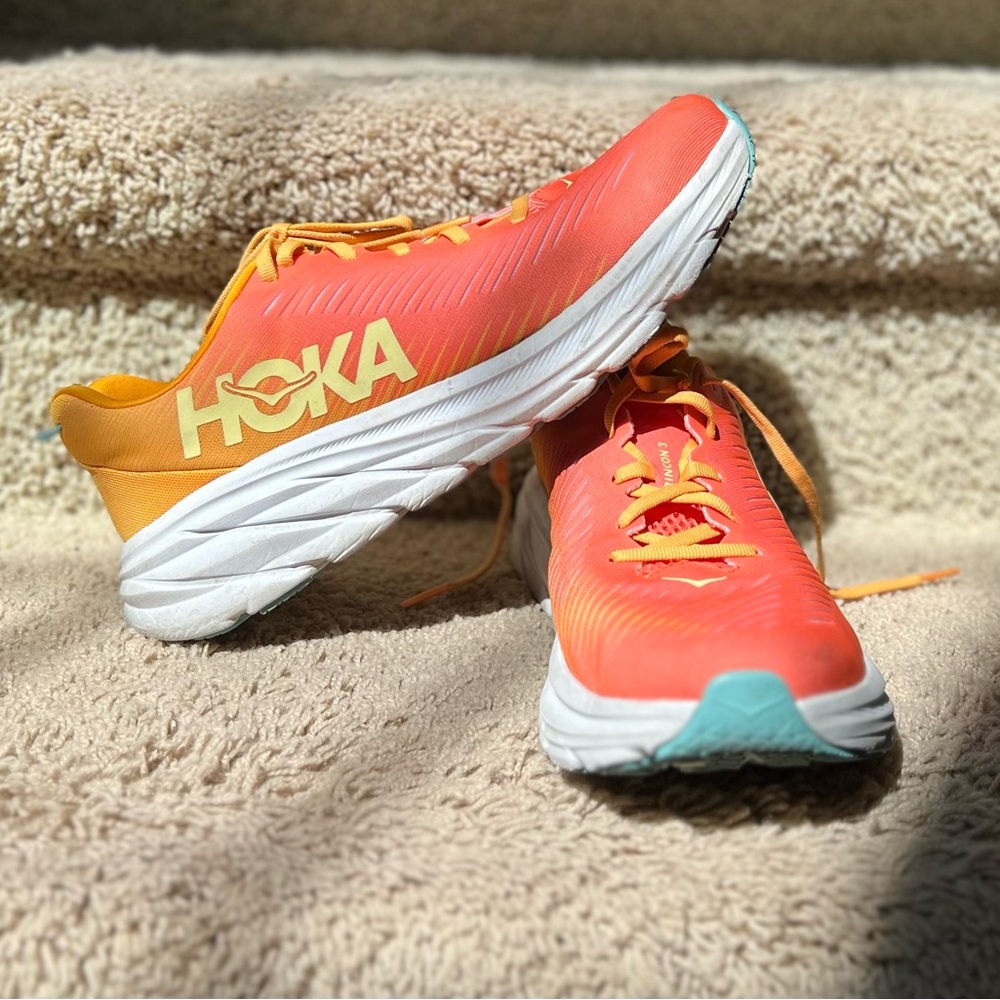Women’s size 9.5B Hoka Rincon 3’s; color is primarily orange